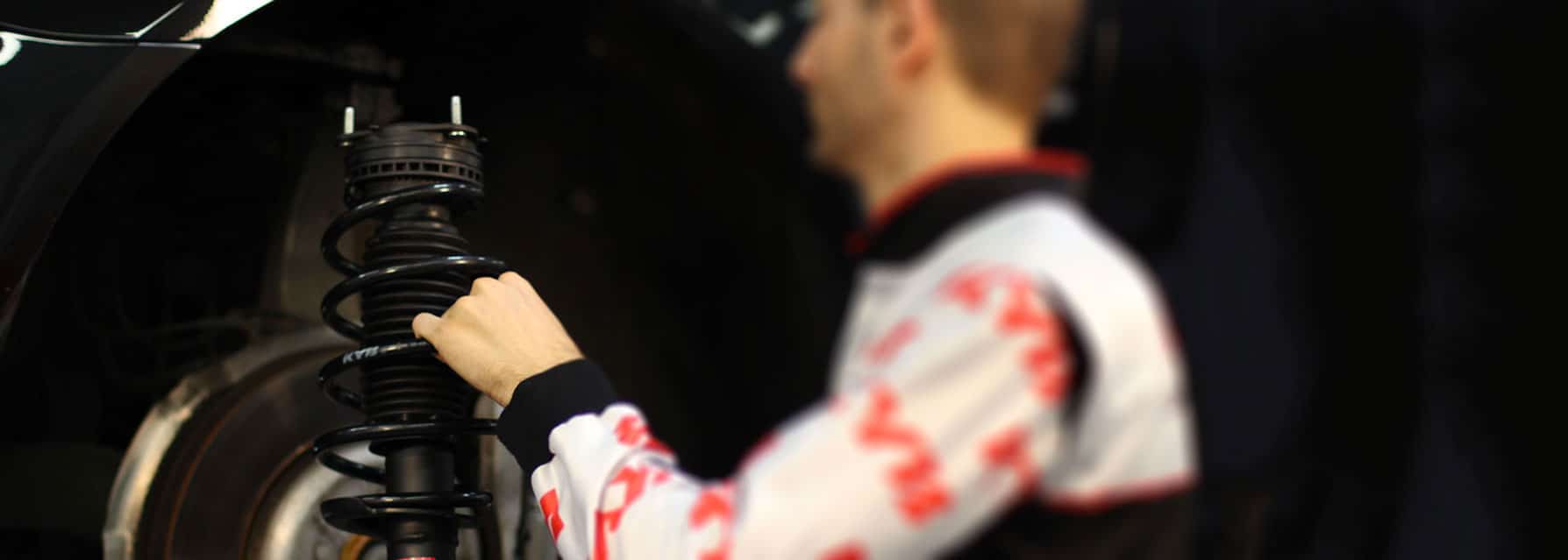 KYB technician fitting a shock absorber